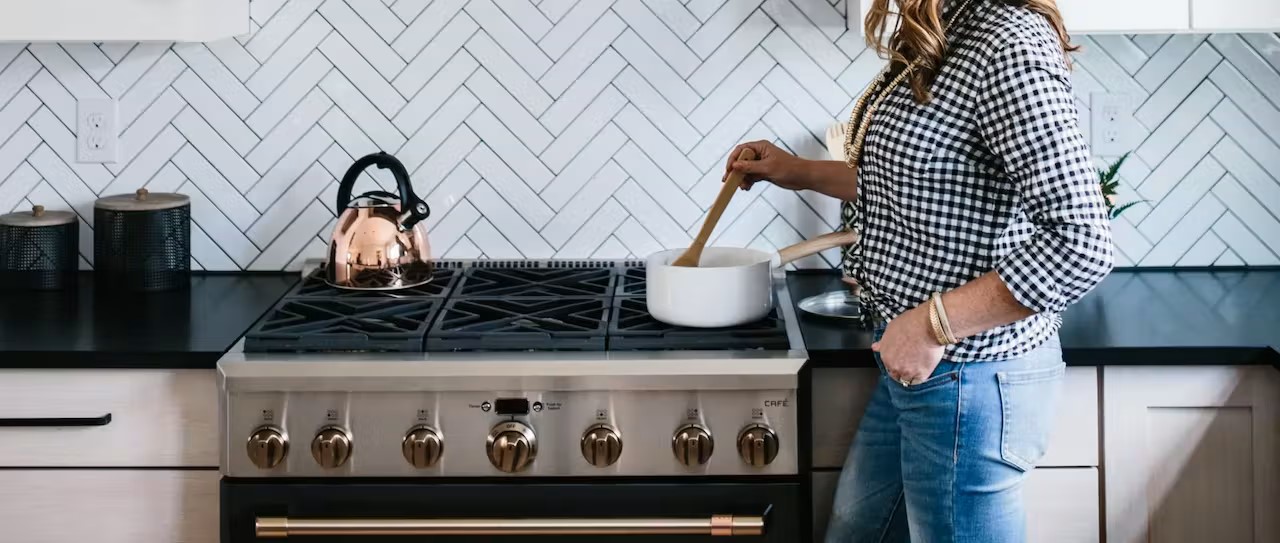 woman stirring pot on cafe range