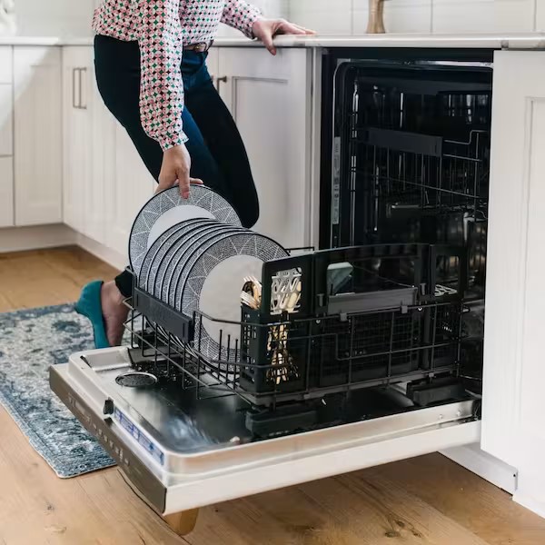 woman putting plate into dishwasher